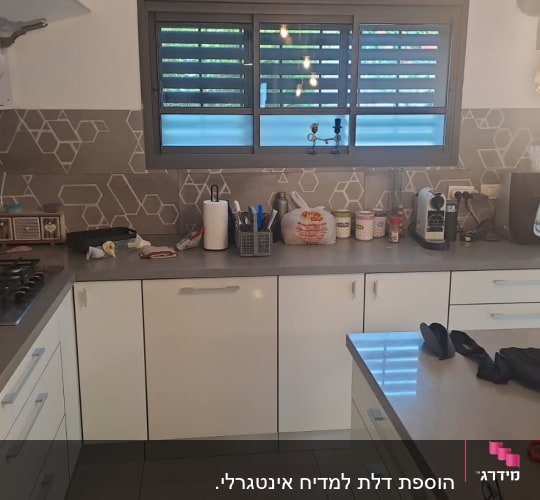 מטבח מודרני עם ארונות לבנים, משטח עבודה אפור ואי למטבח